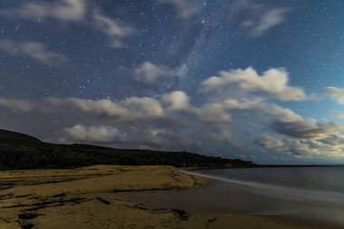 Gecenin karanlığında, Samanyolu 'nun altındaki sahilde ve Avustralya, NSW' nin merkez kıyısındaki Putty Beach 'te yıldızlar..