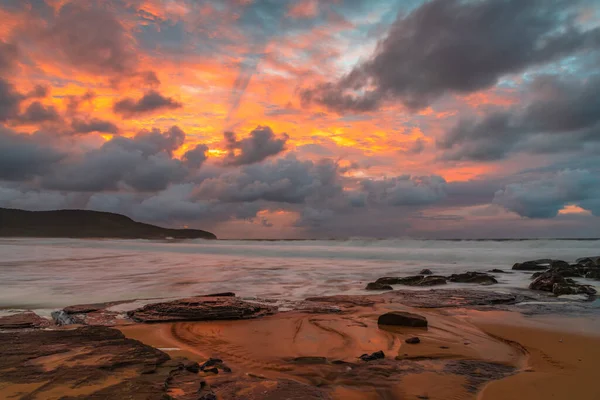 Sunrise at the seaside with clouds and touch of pink in the sky at Killcare Beach on the Central Coast, NSW, Australia.