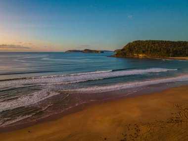 Sunrise seascape with small waves and mostly clear skies at Umina Beach on the Central Coast, NSW, Australia.