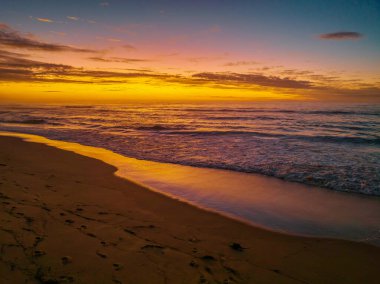 Central Coast, NSW, Avustralya 'daki Shelly Sahili' nde bulutlu gün doğumu denizi..
