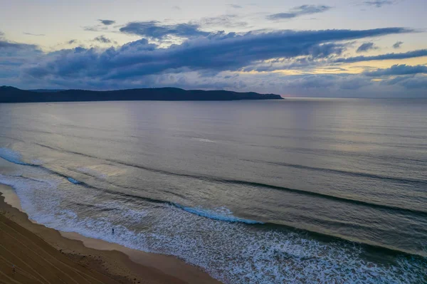 Central Coast, NSW, Avustralya 'daki Umina Sahili' nde bulutlu gün doğumu denizi..