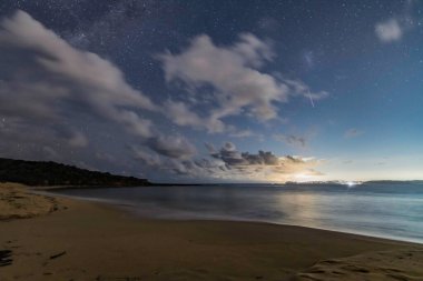 Gecenin karanlığında, Samanyolu 'nun altındaki sahilde ve Avustralya, NSW' nin merkez kıyısındaki Putty Beach 'te yıldızlar..