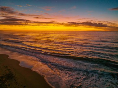 Central Coast, NSW, Avustralya 'daki Shelly Sahili' nde bulutlu gün doğumu denizi..