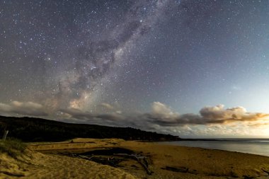 Gecenin karanlığında, Samanyolu 'nun altındaki sahilde ve Avustralya, NSW' nin merkez kıyısındaki Putty Beach 'te yıldızlar..