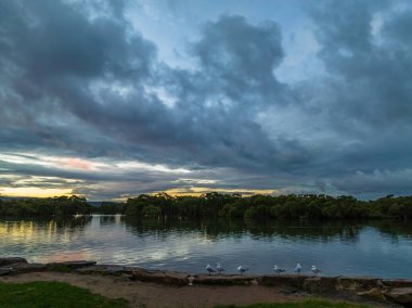 Körfez üzerinde hava günbatımı uçuşu, yağmur bulutları ile Woy Woy 'da Central Coast, NSW, Avustralya.