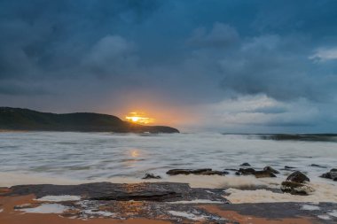 Deniz kenarında gün doğumu bulutlarla ve gökyüzünde pembe bir dokunuşla Central Coast, NSW, Avustralya 'daki Killcare Plajı' nda..