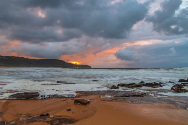 Deniz kenarında gün doğumu bulutlarla ve gökyüzünde pembe bir dokunuşla Central Coast, NSW, Avustralya 'daki Killcare Plajı' nda..