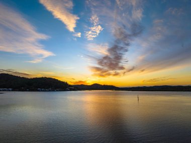 Orta Sahildeki Woy Woy, NSW, Avustralya 'da yüksek bulutlu ve yumuşak pastel renklere sahip hava gündoğumu su manzarası..