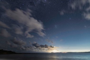 Gecenin karanlığında, Samanyolu 'nun altındaki sahilde ve Avustralya, NSW' nin merkez kıyısındaki Putty Beach 'te yıldızlar..