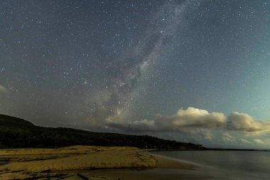 Gecenin karanlığında, Samanyolu 'nun altındaki sahilde ve Avustralya, NSW' nin merkez kıyısındaki Putty Beach 'te yıldızlar..