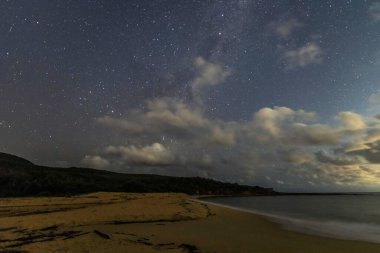 Gecenin karanlığında, Samanyolu 'nun altındaki sahilde ve Avustralya, NSW' nin merkez kıyısındaki Putty Beach 'te yıldızlar..