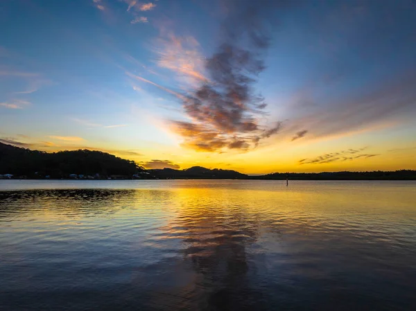Orta Sahildeki Woy Woy, NSW, Avustralya 'da yüksek bulutlu ve yumuşak pastel renklere sahip hava gündoğumu su manzarası..