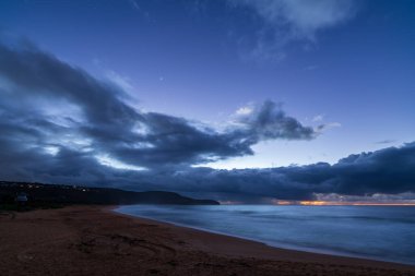 Deniz kıyısında gün doğumu, Killcare Sahili 'nde yağmur bulutları, NSW, Avustralya.