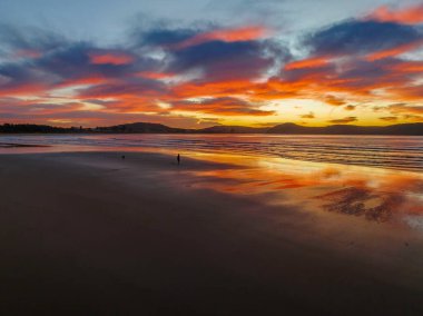 Umina Point 'te, Umina Sahili' nde, NSW 'de, Avustralya' da, Umina Sahili 'nde, renkli yüksek bulutlarla kumsalda gün doğumu..