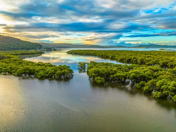 Aerial sunset flight over the bay with rain clouds at Woy Woy on the Central Coast, NSW, Australia.