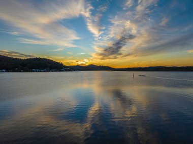 Orta Sahildeki Woy Woy, NSW, Avustralya 'da yüksek bulutlu ve yumuşak pastel renklere sahip hava gündoğumu su manzarası..