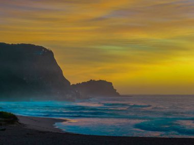 Aerial sunrise with high clouds and gentle sea at Avoca Beach on the Central Coast, NSW, Australia.