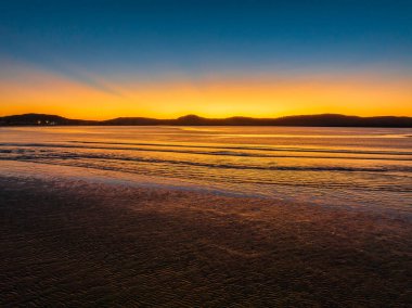 Sunrise seascape with calm sea and clear skies at Umina Point, Umina Beach on the Central Coast, NSW, Australia.