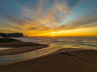 Avoca Lagoon ve Avoca Sahili 'ndeki NSW, Avustralya' daki Avoca Sahili 'nde bulutlu ve yumuşak denizli hava gündoğumu.