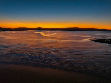 Sunrise seascape with calm sea and clear skies at Umina Point, Umina Beach on the Central Coast, NSW, Australia.