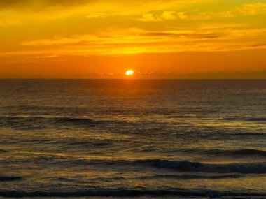 Avoca Lagoon ve Avoca Sahili 'ndeki NSW, Avustralya' daki Avoca Sahili 'nde bulutlu ve yumuşak denizli hava gündoğumu.