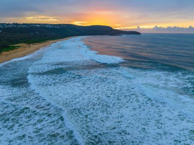 Sunrise seascape with colourful cloud covered sky at Killcare Beach on the Central Coast, NSW, Australia.