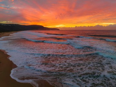 Sunrise seascape with colourful cloud covered sky at Killcare Beach on the Central Coast, NSW, Australia.