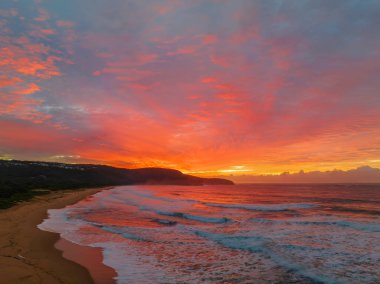 Sunrise seascape with colourful cloud covered sky at Killcare Beach on the Central Coast, NSW, Australia.