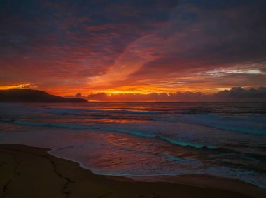 Sunrise seascape with colourful cloud covered sky at Killcare Beach on the Central Coast, NSW, Australia.