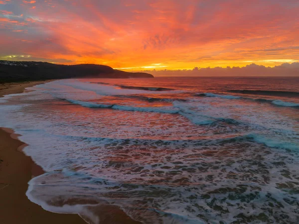 Sunrise seascape with colourful cloud covered sky at Killcare Beach on the Central Coast, NSW, Australia.