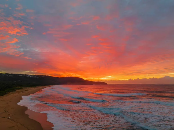 Sunrise seascape with colourful cloud covered sky at Killcare Beach on the Central Coast, NSW, Australia.