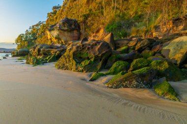 Sunrise seascape with flat surf and clear skies at Umina Point, Umina Beach on the Central Coast, NSW, Australia.