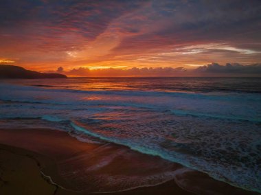 Sunrise seascape with colourful cloud covered sky at Killcare Beach on the Central Coast, NSW, Australia.