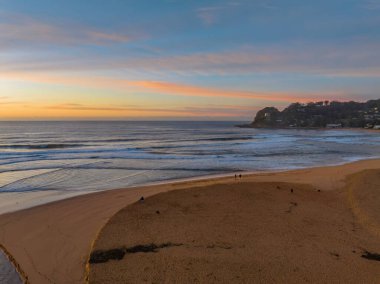 Avoca Lagoon ve Avoca Sahili 'ndeki NSW, Avustralya' daki Avoca Sahili 'nde bulutlu ve yumuşak denizli hava gündoğumu.