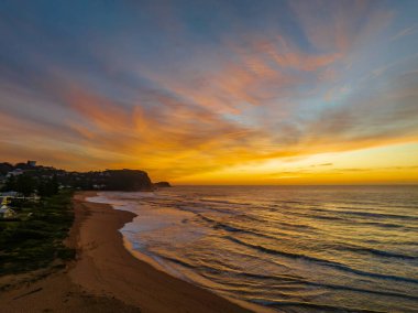 Aerial sunrise with high clouds and gentle sea at Avoca Beach on the Central Coast, NSW, Australia.
