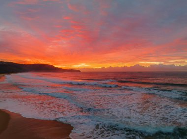 Sunrise seascape with colourful cloud covered sky at Killcare Beach on the Central Coast, NSW, Australia.
