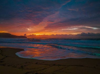 Sunrise seascape with colourful cloud covered sky at Killcare Beach on the Central Coast, NSW, Australia.