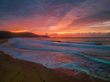 Sunrise seascape with colourful cloud covered sky at Killcare Beach on the Central Coast, NSW, Australia.