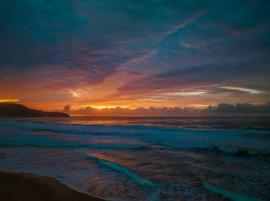 Sunrise seascape with colourful cloud covered sky at Killcare Beach on the Central Coast, NSW, Australia.
