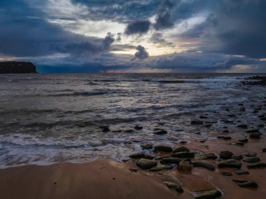 Central Coast, NSW, Avustralya 'daki Macmaster Sahili' nden deniz kenarında yağmurlu bir gün doğumu..