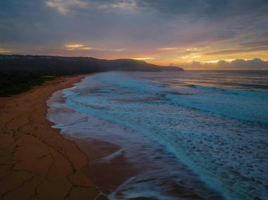 Sunrise seascape with colourful cloud covered sky at Killcare Beach on the Central Coast, NSW, Australia.