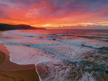 Sunrise seascape with colourful cloud covered sky at Killcare Beach on the Central Coast, NSW, Australia.