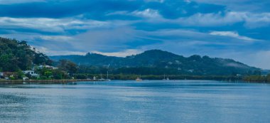 Yağmur bulutları, sis ve Woy Woy 'daki yansımalarla birlikte NSW, Avustralya.