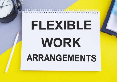Flexible Work Arrangements. text on white notepad on gray, yellow background, Top view flat lay, business concept