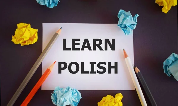 learn polish. text written on white paper,Pencils over white paper, crumpled papers page, dark background,Top view flat lay, business concept