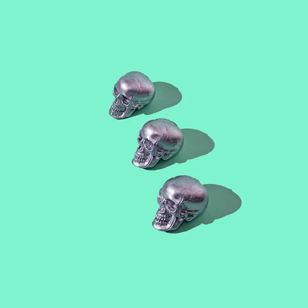 石灰緑の背景に3つの銀の頭蓋骨 不気味なハロウィーンパーティーの招待状またはバナー — ストック写真