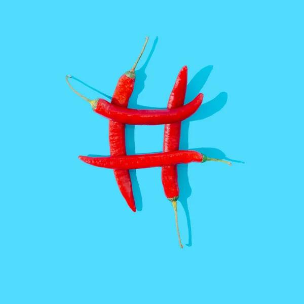 青い背景に赤唐辛子4枚をハッシュタグの形で組み立てました ソーシャルメディアやマーケティングのアイデア創造的なコンセプト 現代ビジネスアートデザイン — ストック写真