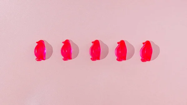 Beş neon pembe penguen düzgün bir şekilde parlak pastel pembe arka plana dizilmiş. Dondurucu soğuk, güzel kış yaratıcı konsepti ya da geçmişi. Kış moda reklamları için pankart ya da duvar kağıdı.