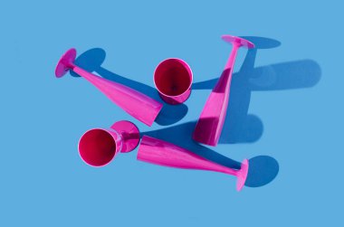 Pastel mavi arka planda beş mor şampanya kadehi. Parti daveti, web pankartı veya kutlama için yaratıcı tasarım.