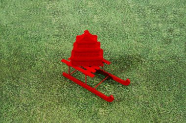 Yapay çimen arka planında kırmızı kızaklı Çin kırmızı tapınağı. Çin Yeni Yıl bayrağı ya da kartı için gerçeküstü yaratıcı bir kavram. Gelenek modern sanatsal tasarıma karşı.